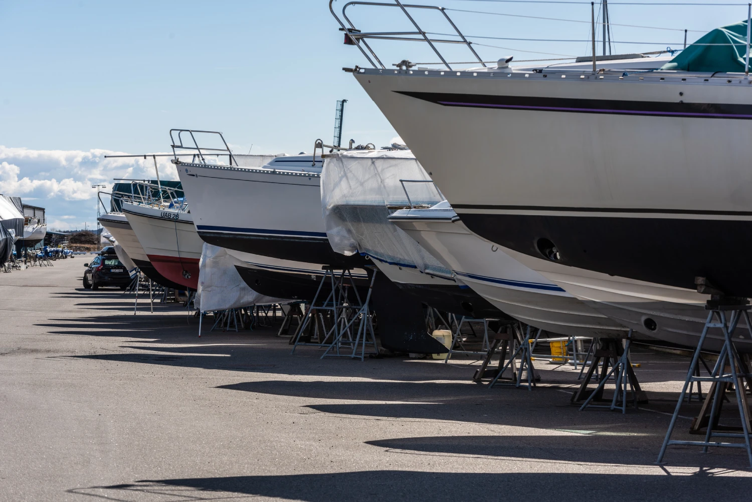 Matthew's Boat and RV Storage Footer banner Long row of sailboats laid up at a parking lot.