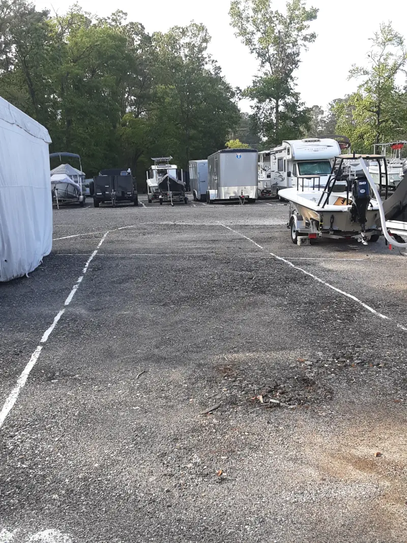 Storage Lot A boat on a trailer is parked in a storage lot at Matthews Boat and RV Storage.